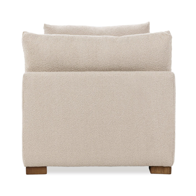 Upholstered daybed end view, textured light beige fabric, back cushion and wooden legs