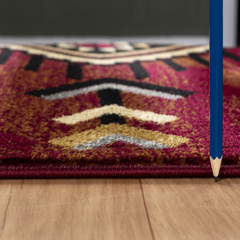Southwest area rug corner with red textured pile and geometric diamond motif