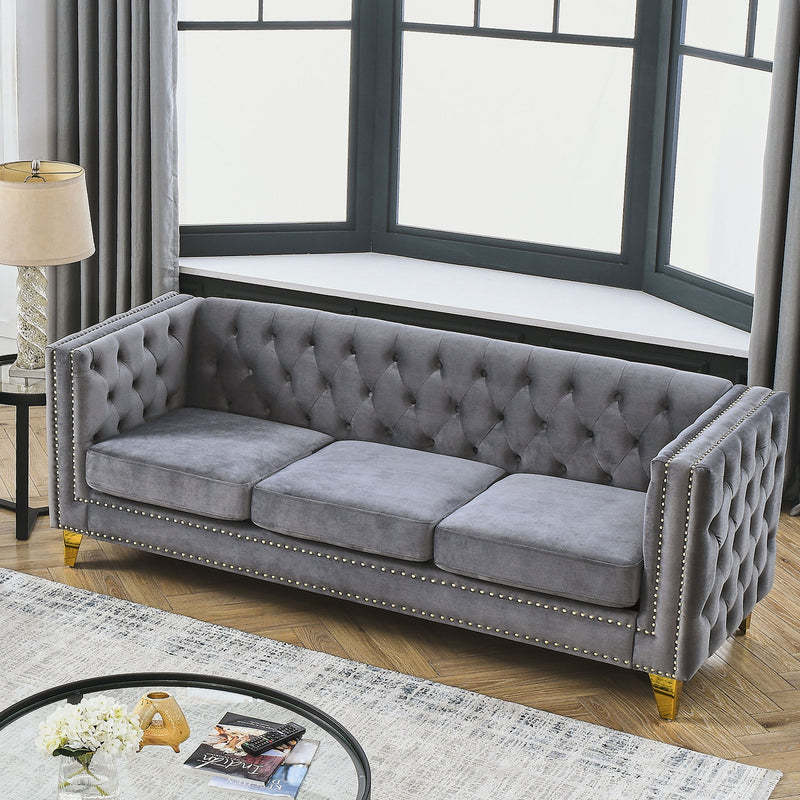 Gray button-tufted sofa with nailhead trim, two seat cushions, and wood legs
