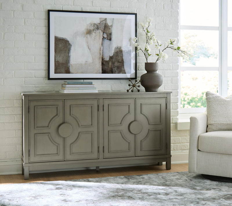 Warm gray accent cabinet with four raised panel doors and round center knobs