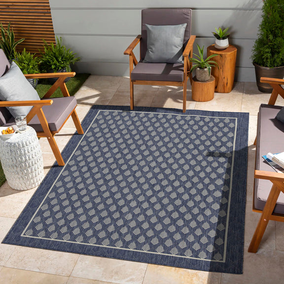 Blue area rug with repeating diamond pattern on an outdoor floor