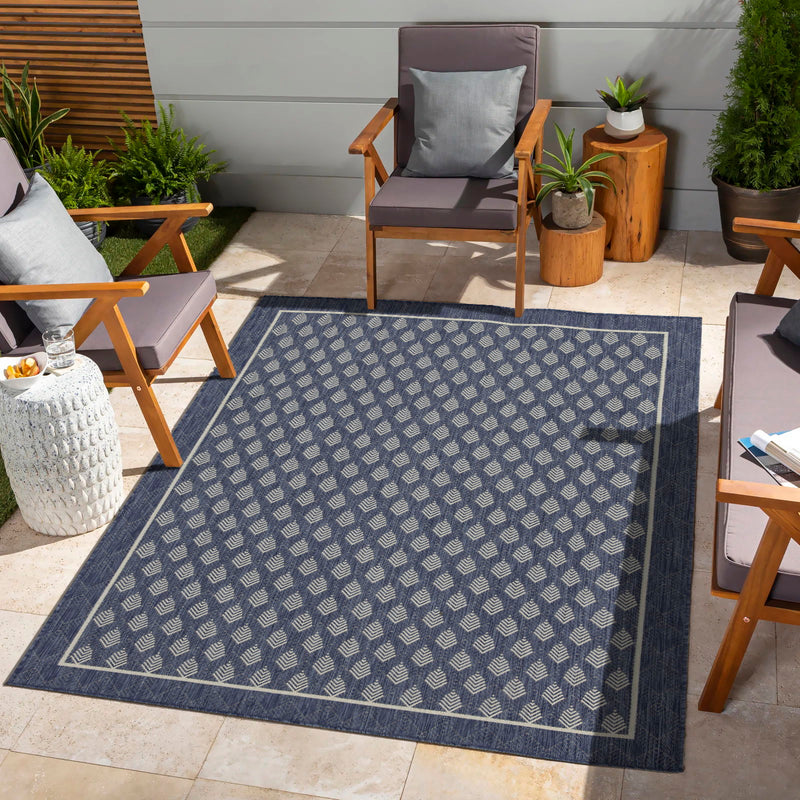 Blue area rug with repeating diamond pattern on an outdoor floor
