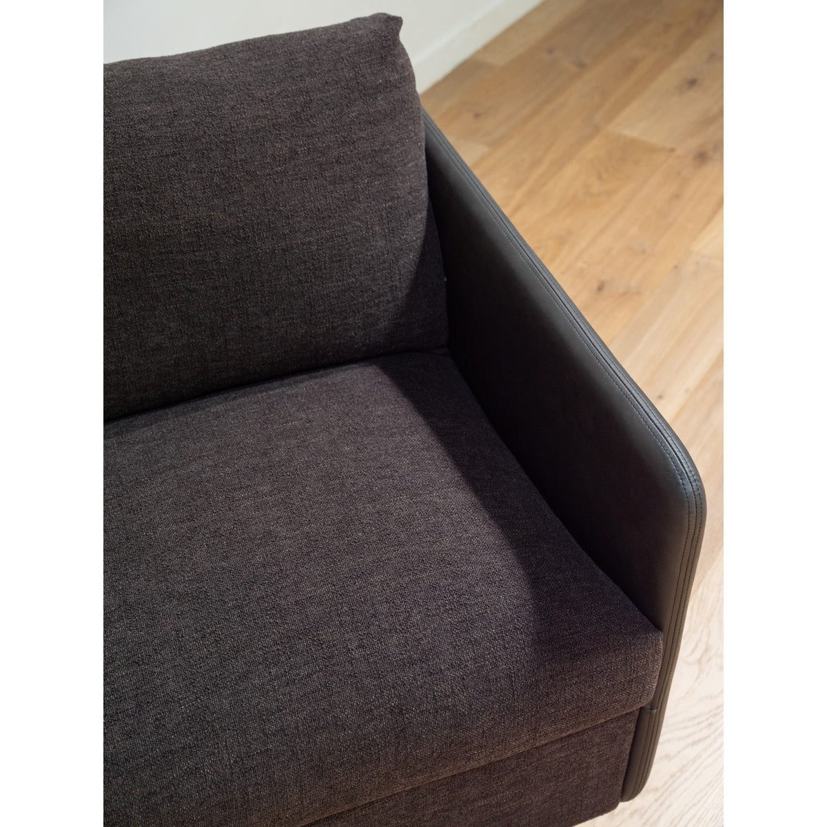 Close-up of warm black upholstered accent chair arm and back cushion