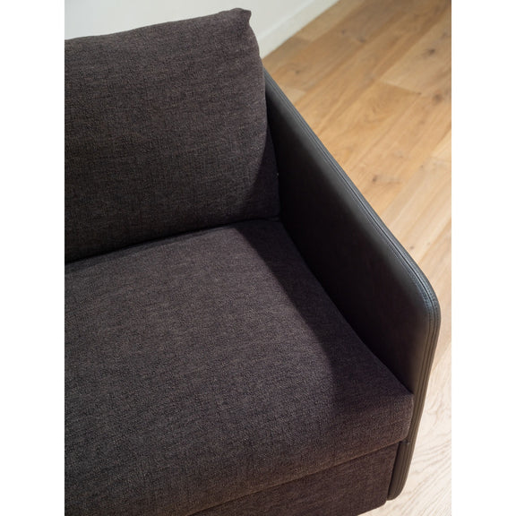Close-up of warm black upholstered accent chair arm and back cushion