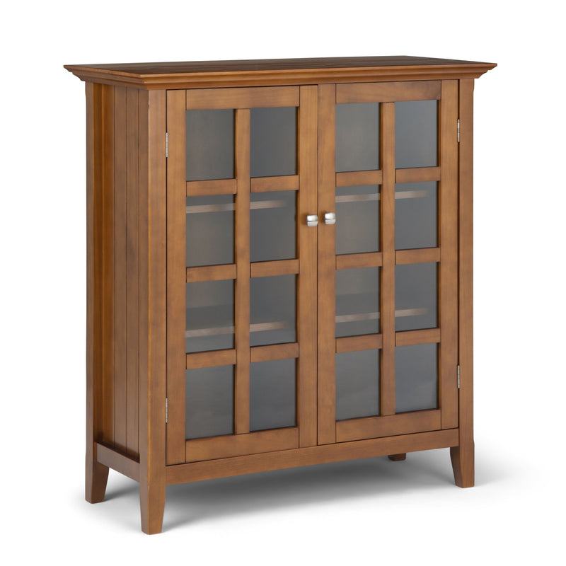 Medium storage cabinet with two glass doors in warm brown, silver knobs, and interior shelves.