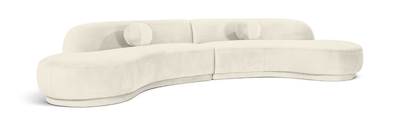 White velvet sectional sofa with tufted cushions and curved chaise profile