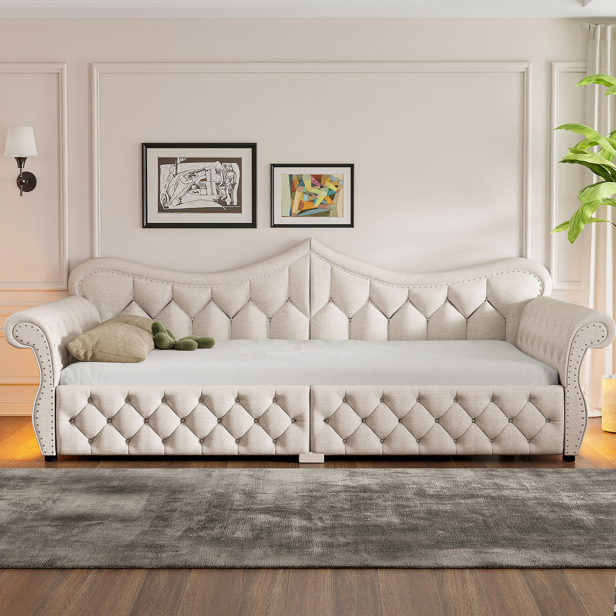 Beige upholstered daybed with button-tufted panels and nailhead trim