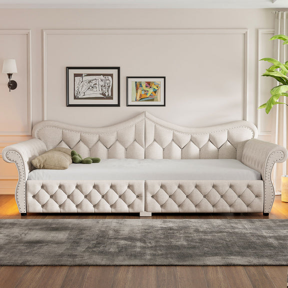 Beige upholstered daybed with button-tufted panels and nailhead trim