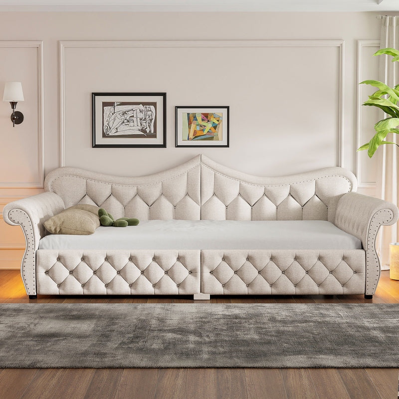 Beige upholstered daybed with button-tufted panels and nailhead trim