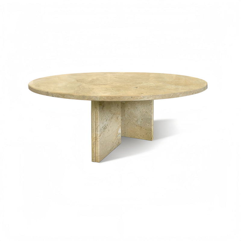 Round beige stone coffee table with natural veining and angled central base leg.
