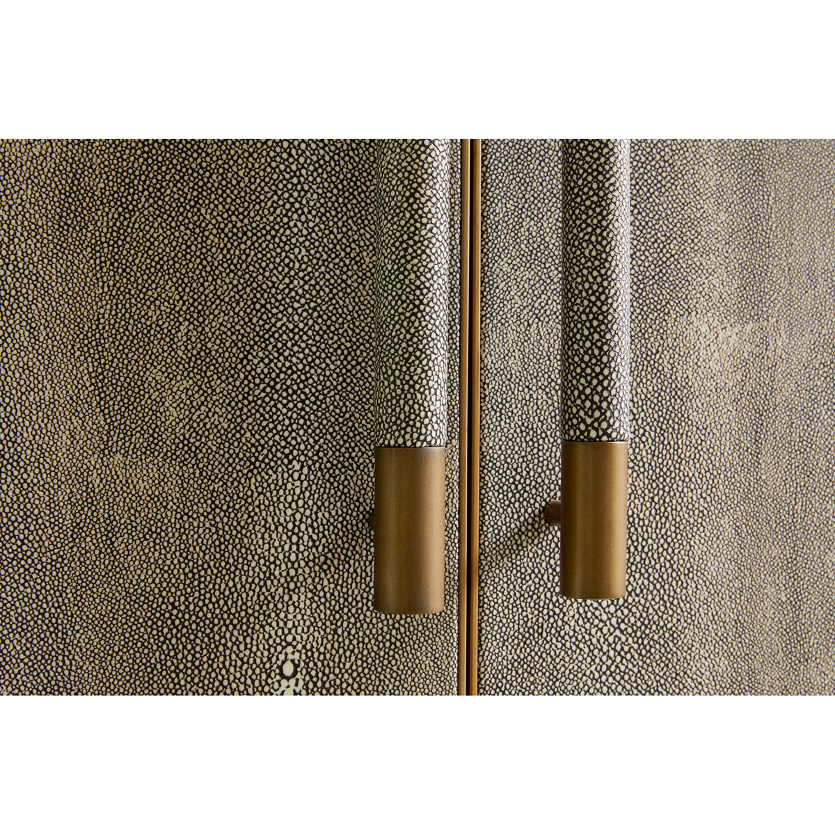 Concrete-textured gray cabinet door with brass-toned vertical bar pull handles