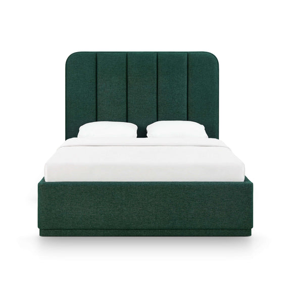 Dark green upholstered bed with tufted vertical headboard and two white pillows.