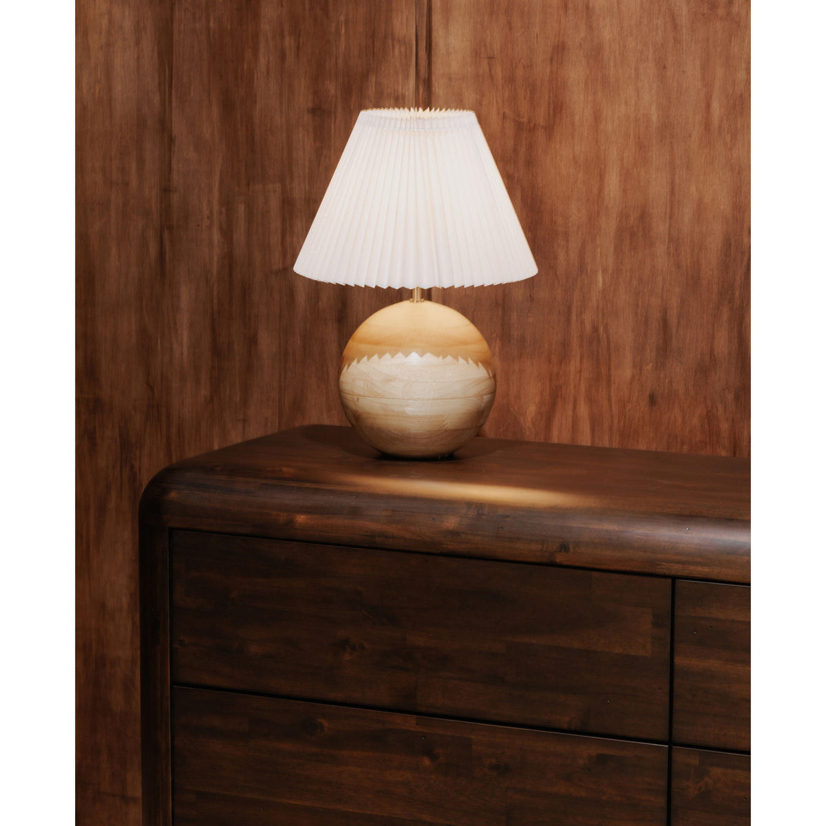Dark brown dresser with curved top rail and lamp on the upper surface