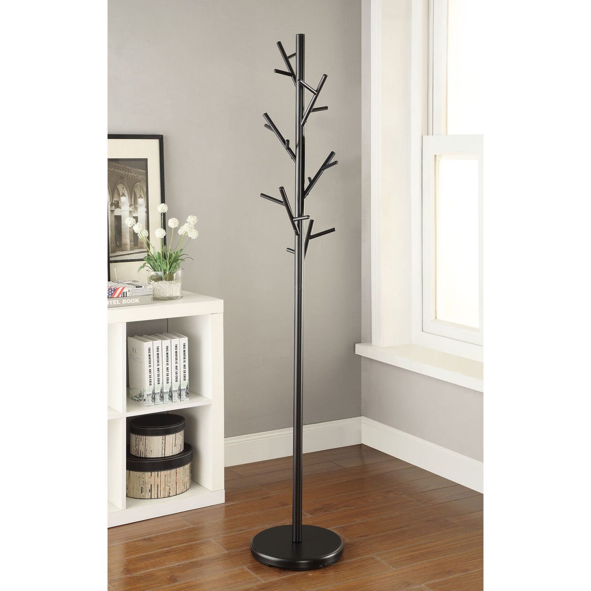 Black freestanding coat rack with branch-style hooks and round base