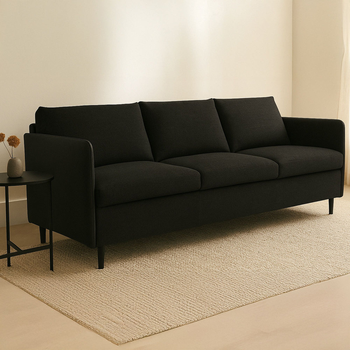 Dark warm black upholstered sofa with wide arms, three seat cushions, boxed back, tapered legs.