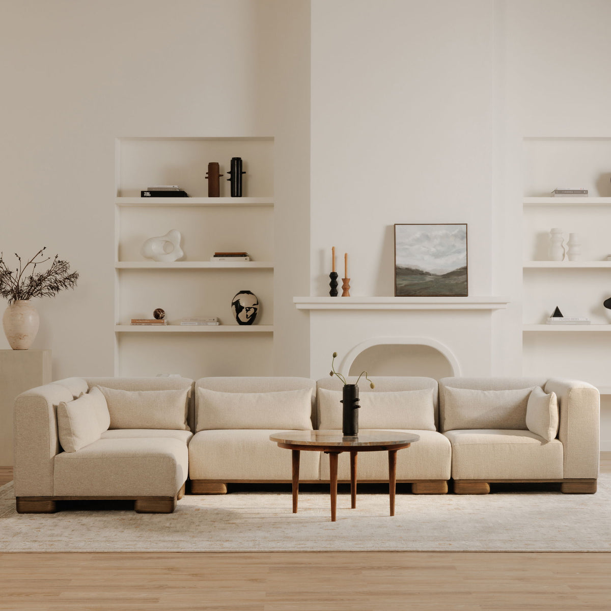 Light oatmeal modular sofa with three seat modules, rounded back cushions, and wood legs