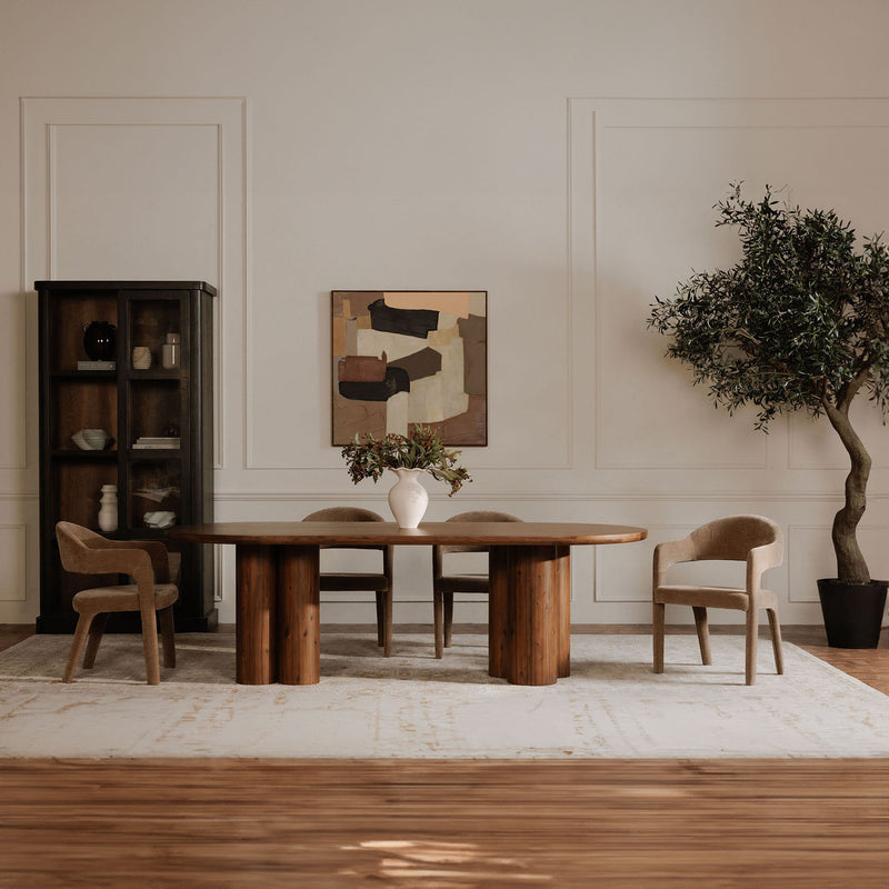 Camel upholstered dining chair with rounded back and curved arms at a dining table