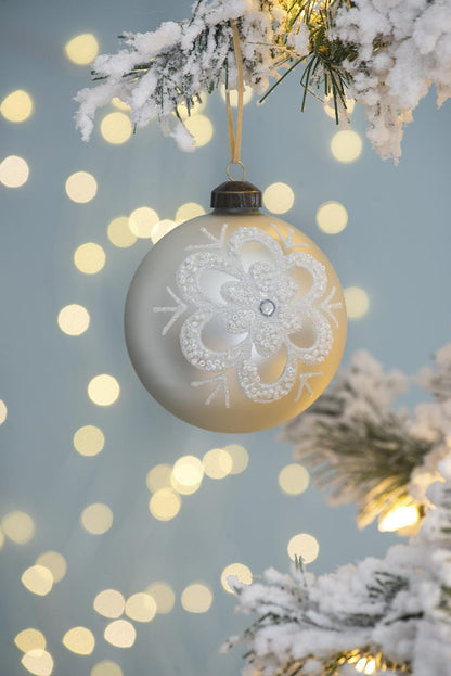 White hanging Christmas ball ornament with detailed snowflake pattern and hanging loop