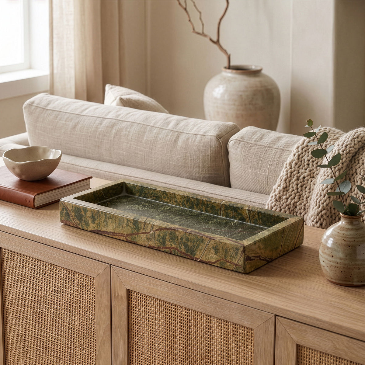 Long rectangular green marble tray with floral accents and candles on top.