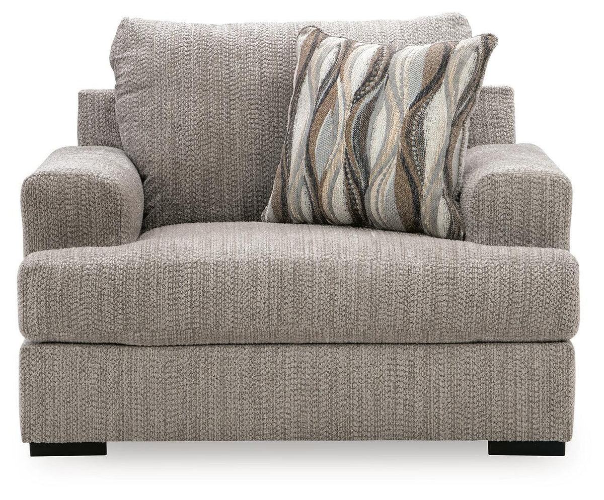 Gray chair and a half with patterned throw pillow, rolled back, and thick arms