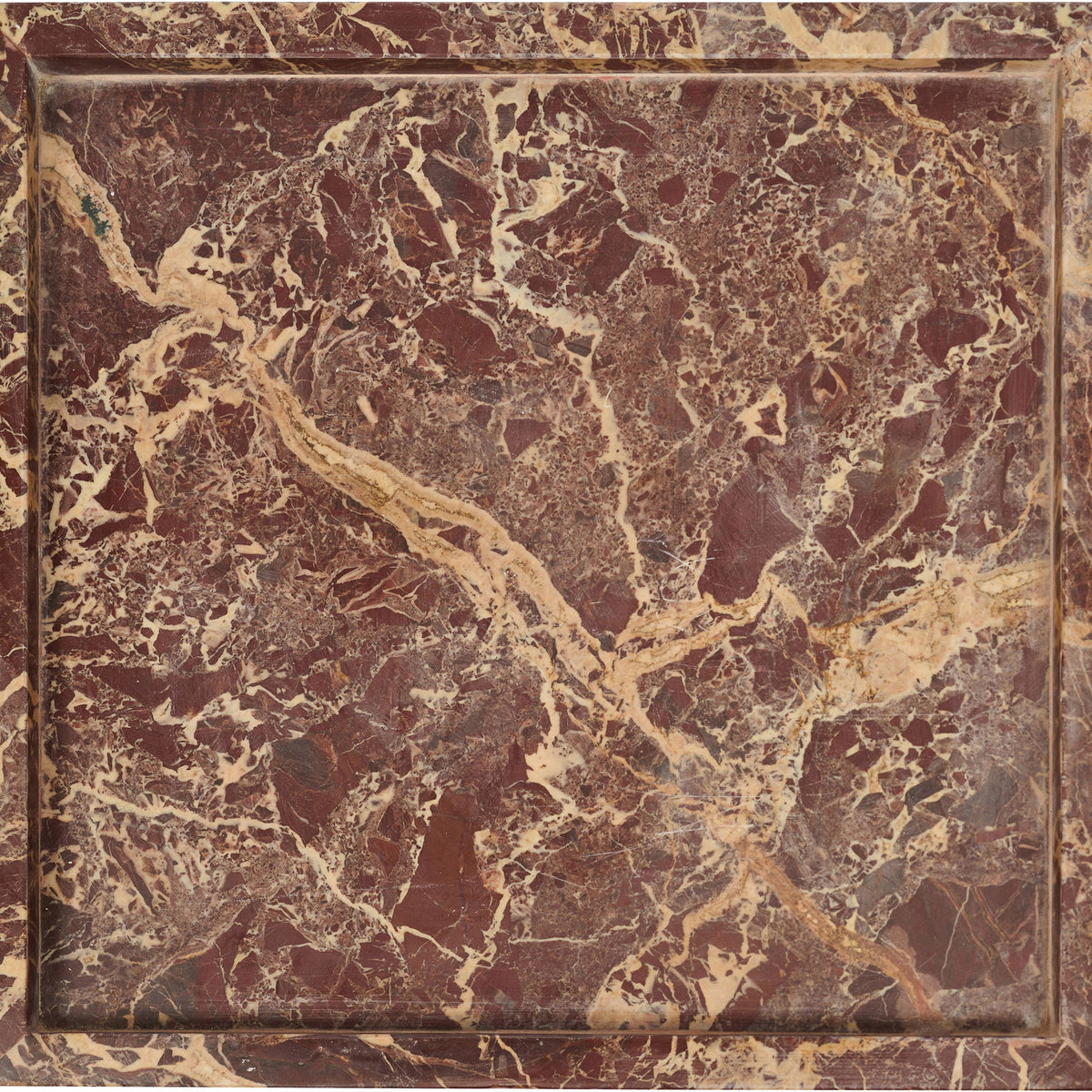 Red-brown marble tray with cream veining and a raised square rim.