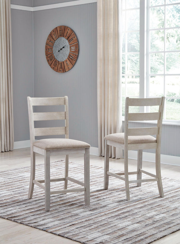 Two white upholstered barstools with ladder backs and light beige seat cushions