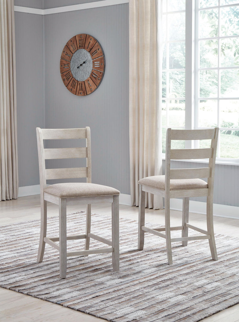 Two white upholstered barstools with ladder backs and light beige seat cushions