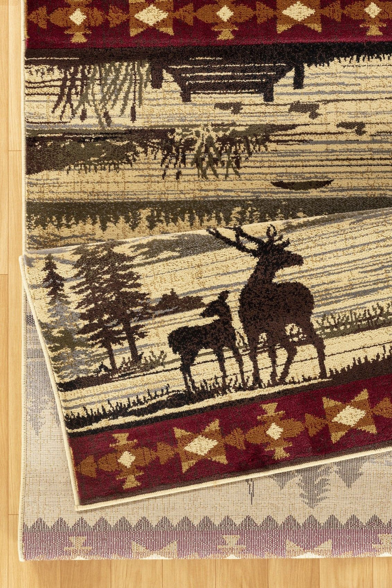 Beige lodge area rug corner with deer and cabin design, dark red band and geometric trim