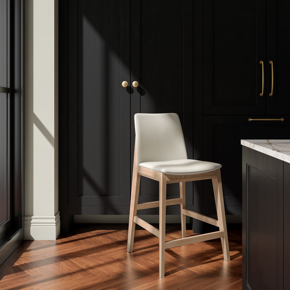 Counter stool with an ivory seat and light brown wood frame, shown at an angle