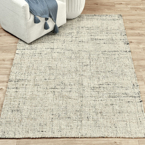 Flatweave area rug in off-white with distressed grid texture and short fringed border