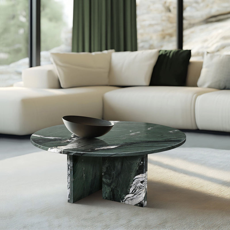 Round dark green marble coffee table with white veining and sturdy block legs.