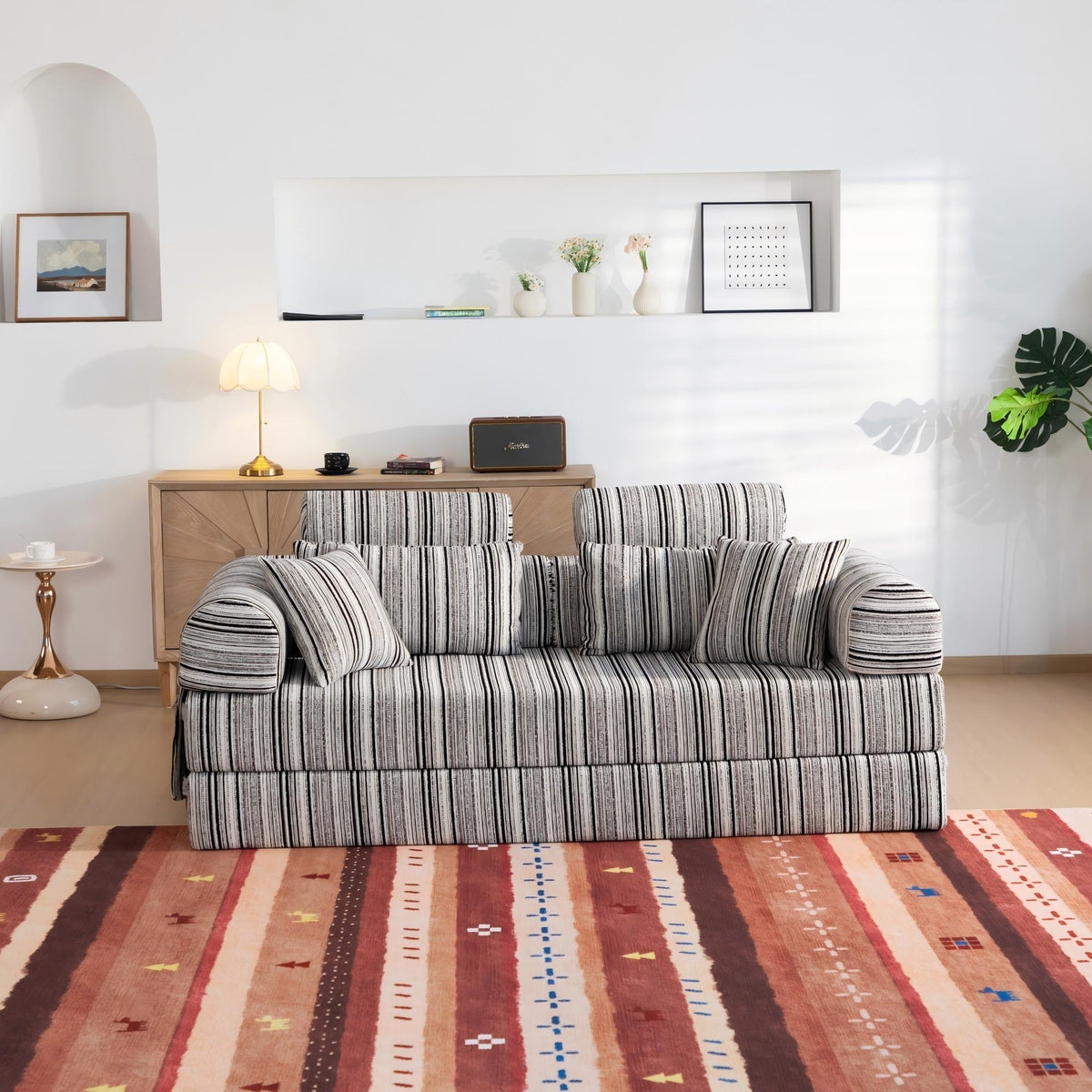 Sleeper sofa bed with striped fabric upholstery and padded armrests, front view