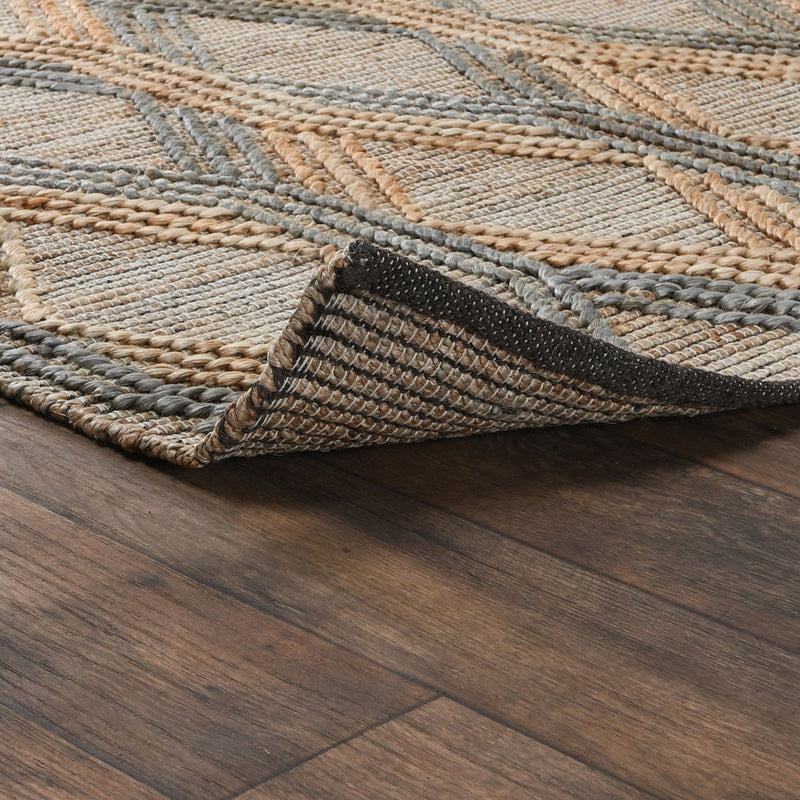 Woven area rug close-up showing beige and blue-gray braid texture and edge detail.