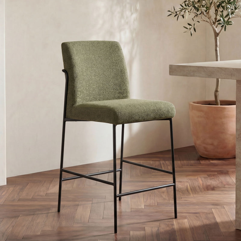 Green fabric counter stool with curved armrest supports, dark metal legs and seat