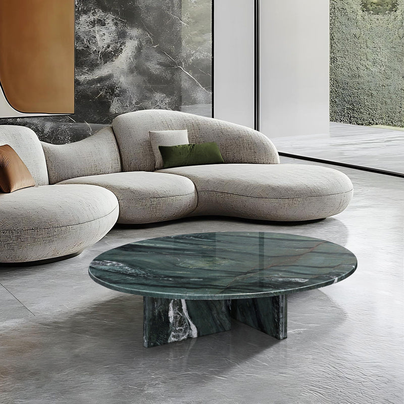 Round stone coffee table with dark green veined marble top and pedestal base