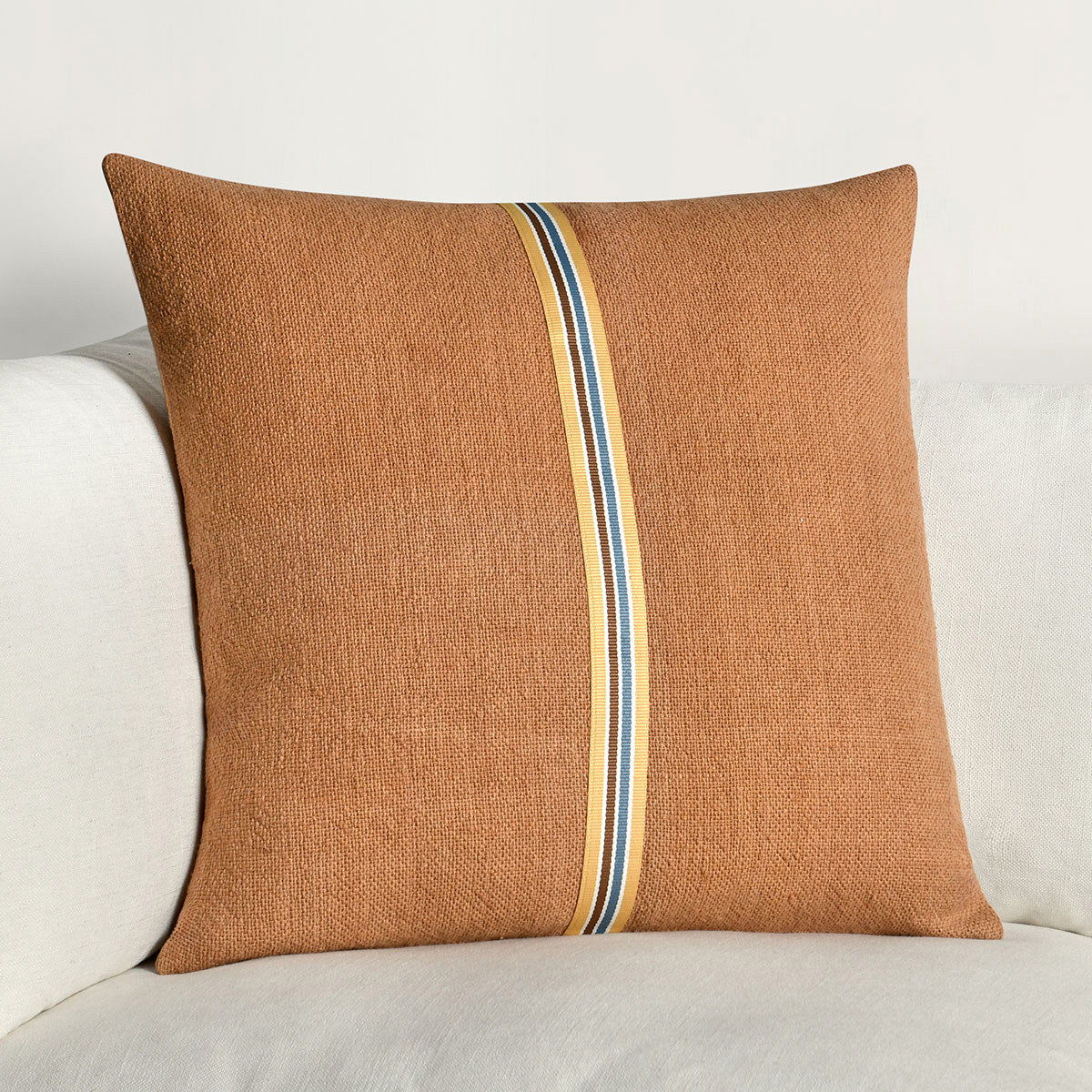 Hazel brown square throw pillow with vertical striped trim band on sofa
