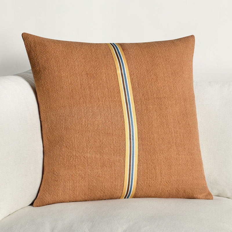 Hazel brown square throw pillow with vertical striped trim band on sofa
