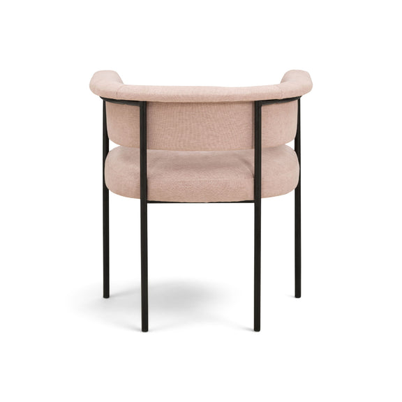 Light pink upholstered dining chair with curved back, padded armrests, and black frame