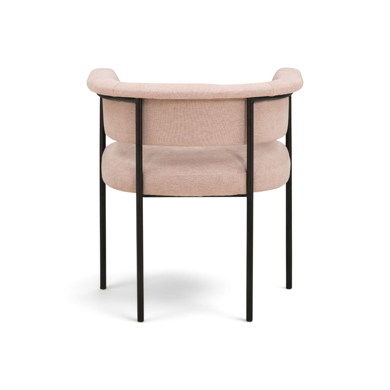 Light pink upholstered dining chair with curved back, padded armrests, and black frame