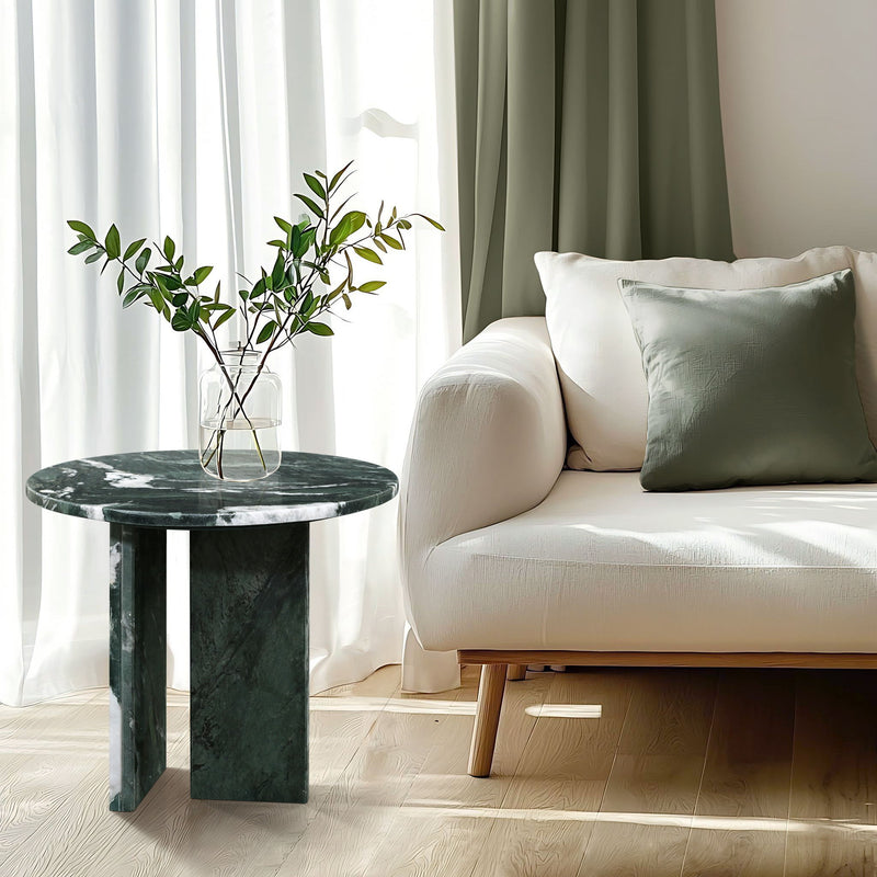 Round dark green marble coffee table with slender stone legs and veined surface