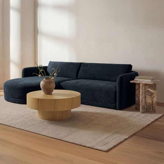 Round rustic oak coffee table with pedestal base on a living room rug