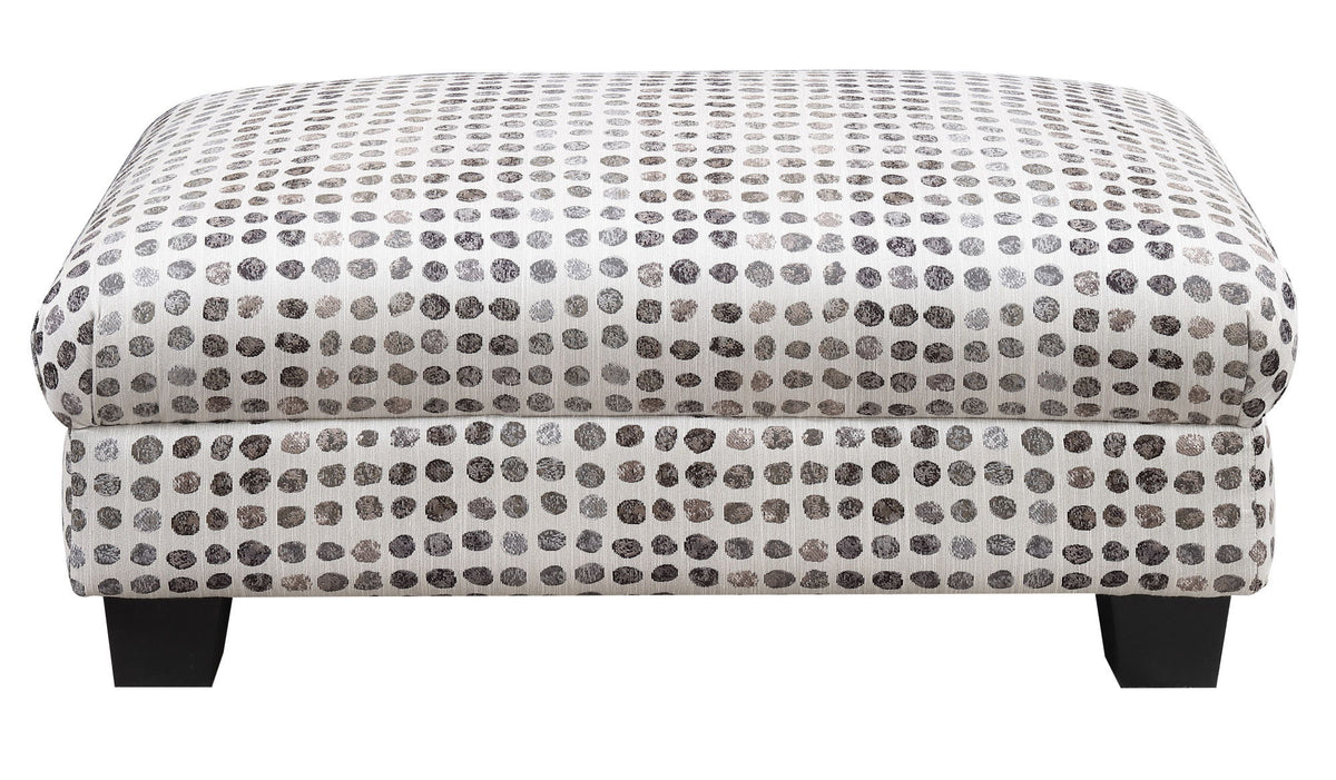 Tufted ottoman top with dark ink-dot pattern on light fabric and dark wooden legs