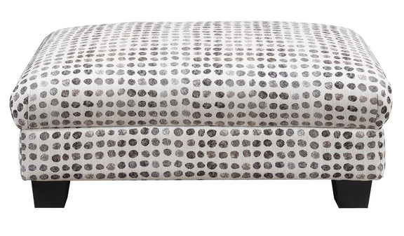 Tufted ottoman top with dark ink-dot pattern on light fabric and dark wooden legs