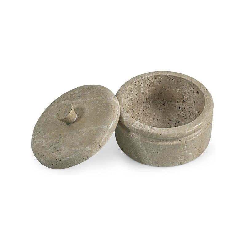 Beige round travertine storage box with lid resting beside base