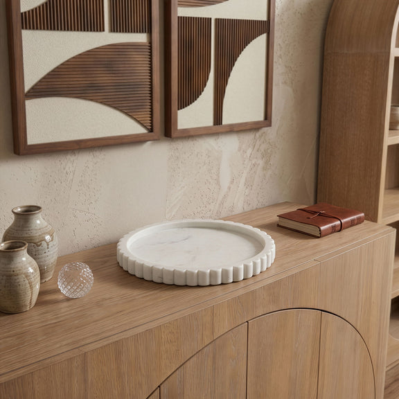 Round white marble tray on wooden console shelf with scalloped outer rim