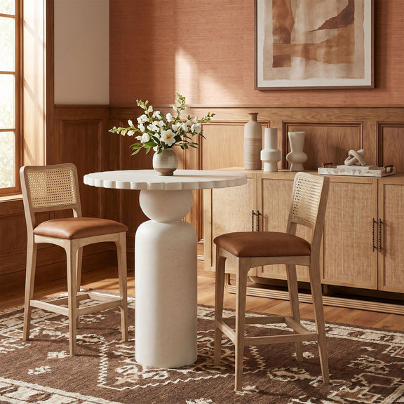 Indoor/outdoor table with round white top and light wood pedestal base