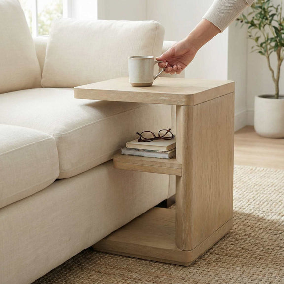Tan chairside table with mug on top and shelves for books or items