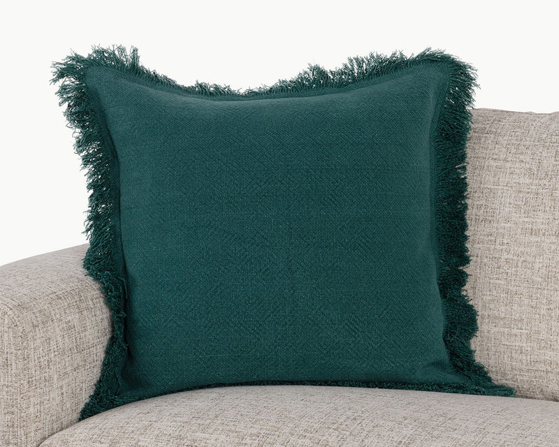 Deep green square accent pillow with textured fabric and fringed border