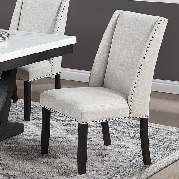 Wingback dining chair in light beige upholstery with nailhead trim and dark wooden legs