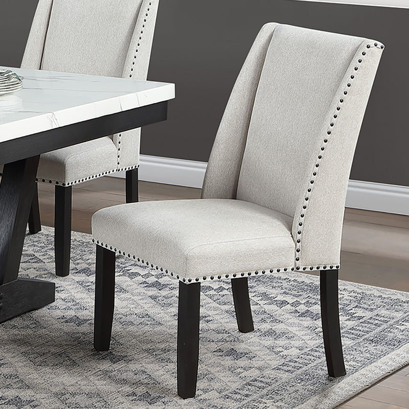 Wingback dining chair in light beige upholstery with nailhead trim and dark wooden legs